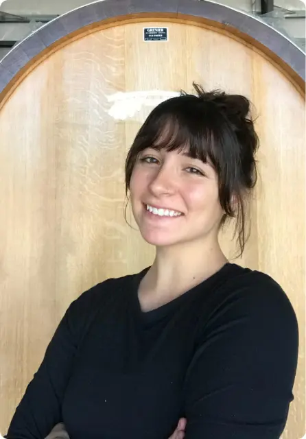 Smiling Elizabeth Stilson holding a PasoSecco sparkling wine bottle